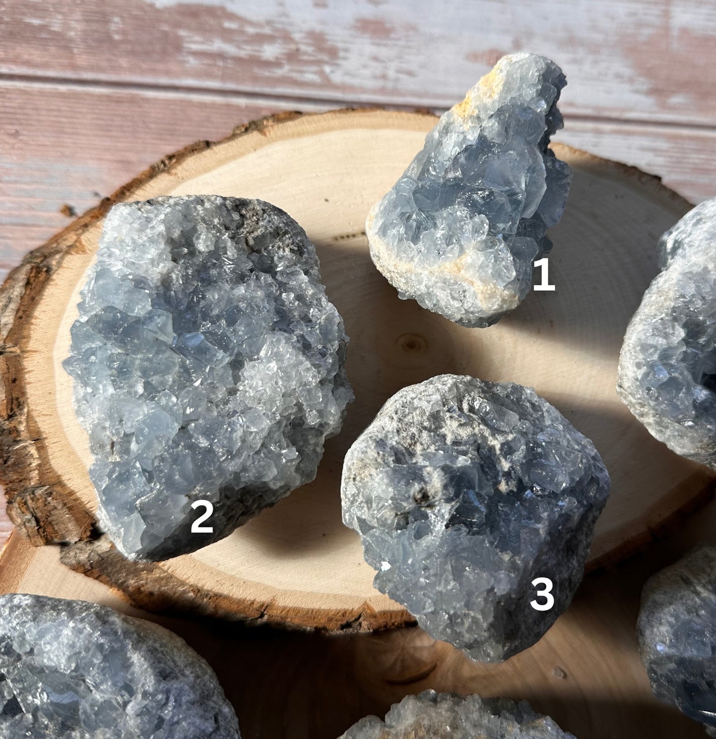 celestite clusters one two and three from madagascar on a wood slice