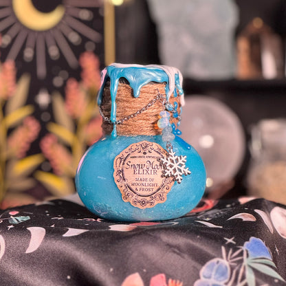 Blue bottle labeled 'Snow Elixir' with decorative elements on a patterned surface.
