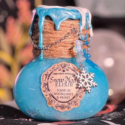 Blue bottle labeled 'Snow Moon Elixir' with decorative elements on a blurred background