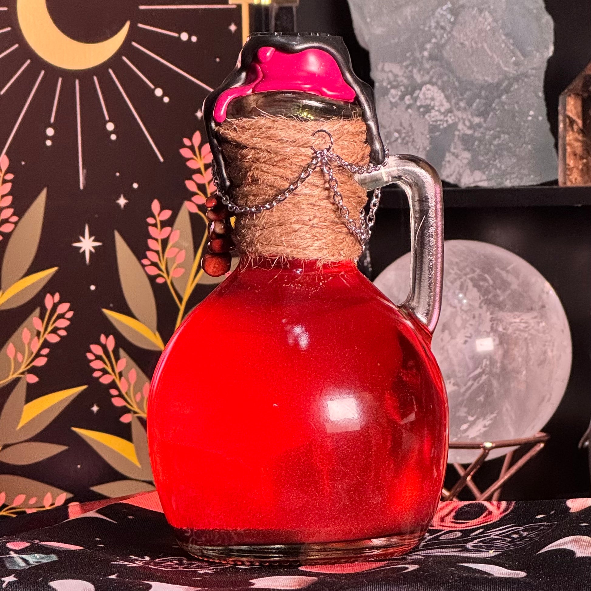 Red glass bottle with a cork stopper on a mystical background with moon and stars.