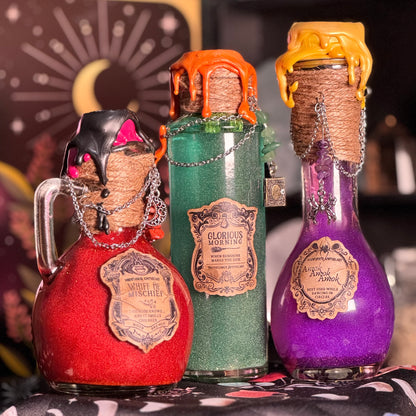 Three decorative bottles with cork stoppers and labels on a patterned surface.