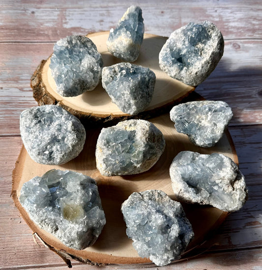 celestite druzy clusters on wood slices and a wooden table top